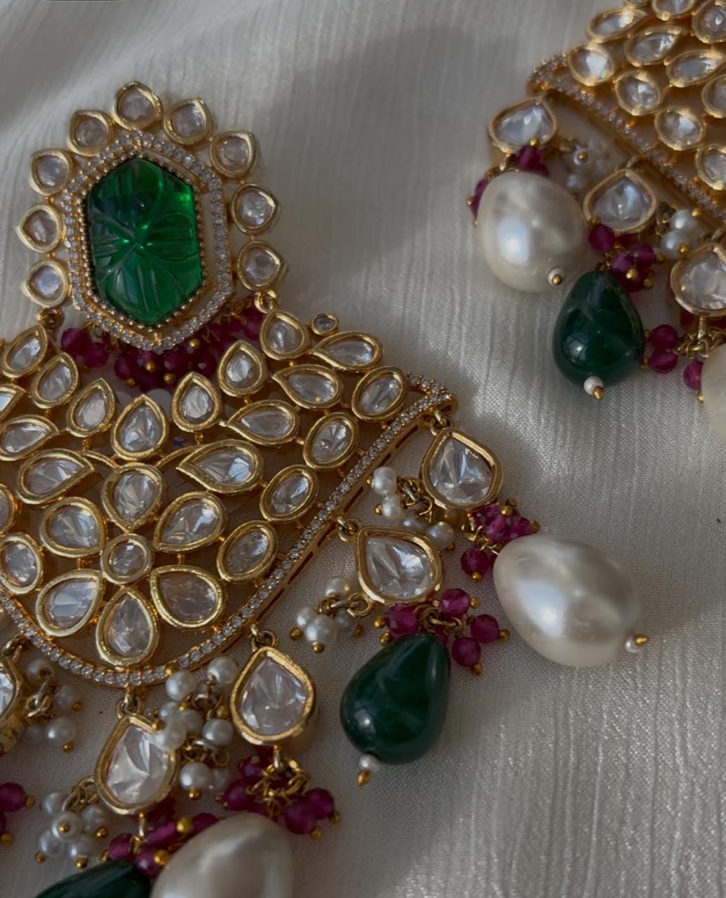 Bridal kundan earrings with carved green stones and dual drop hangings in pearls and emerald.