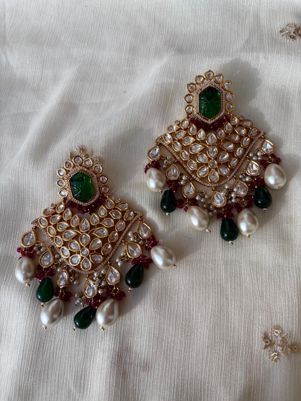Bridal kundan earrings with carved green stones and dual drop hangings in pearls and emerald.