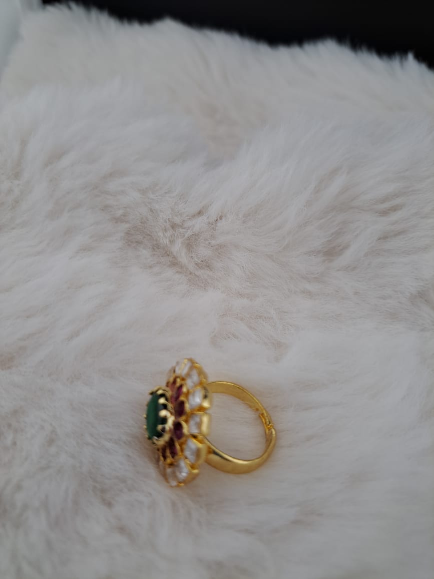 Pachi kundan finger ring with pink kemp stones and emerald in center.